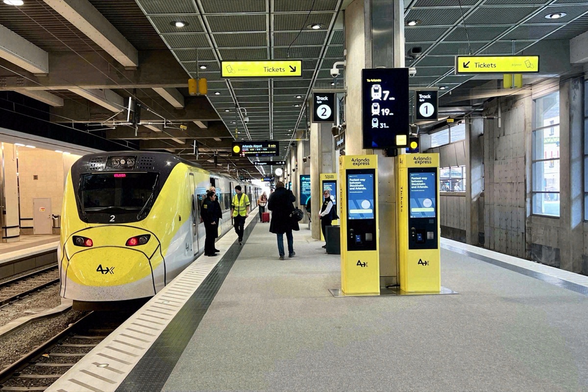 Gelber Zug des Arlanda Express am Bahnsteig neben den Ticketautomaten